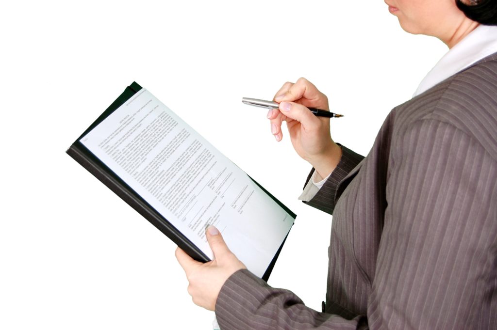 woman signing a sheet of paper